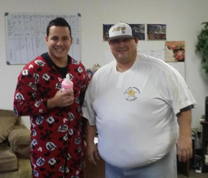 Two men dressed up for Halloween. Man on left dressed like a baby and man on the right dressed like a baseball player