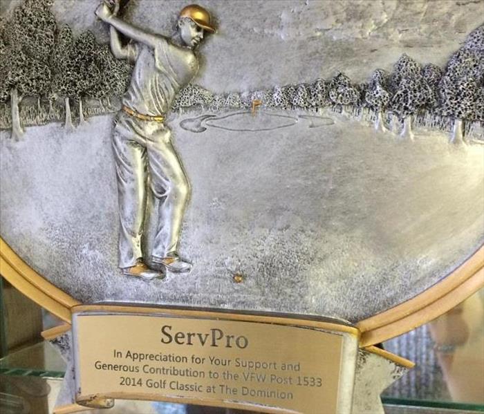 SERVPRO plaque with a bronze engraving and showing a man golfing with a gold hat on