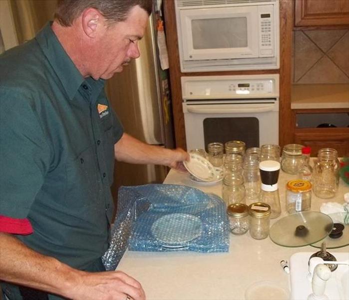Man using bubble wrap to package glasses
