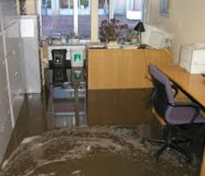 Office with flood waters rising around chairs and desk