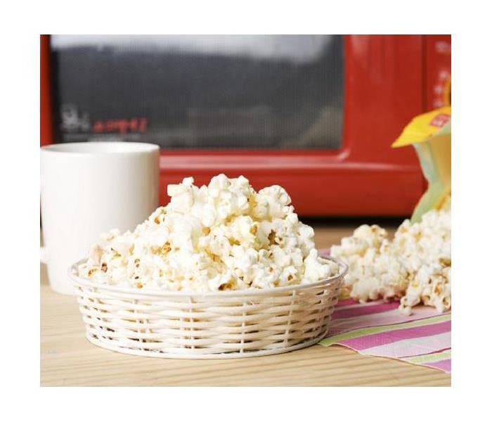 Popcorn in a basket in front of a red microwave