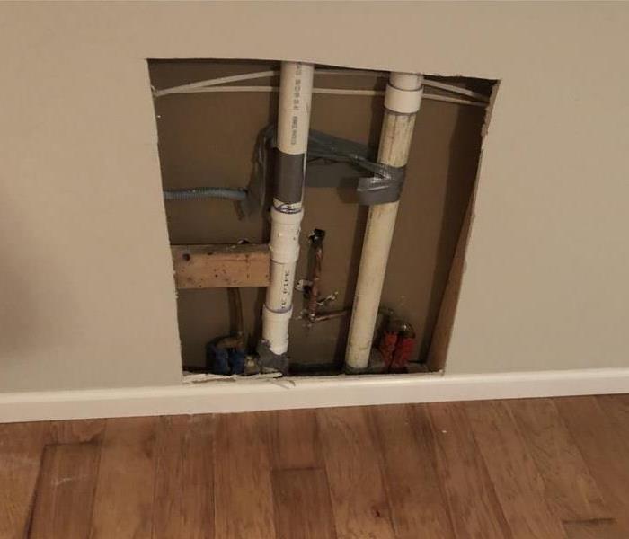 Two pipes behind drywall