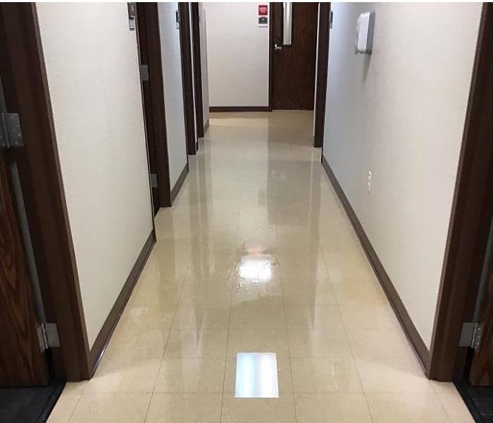 hallway of commercial building showing water on floor