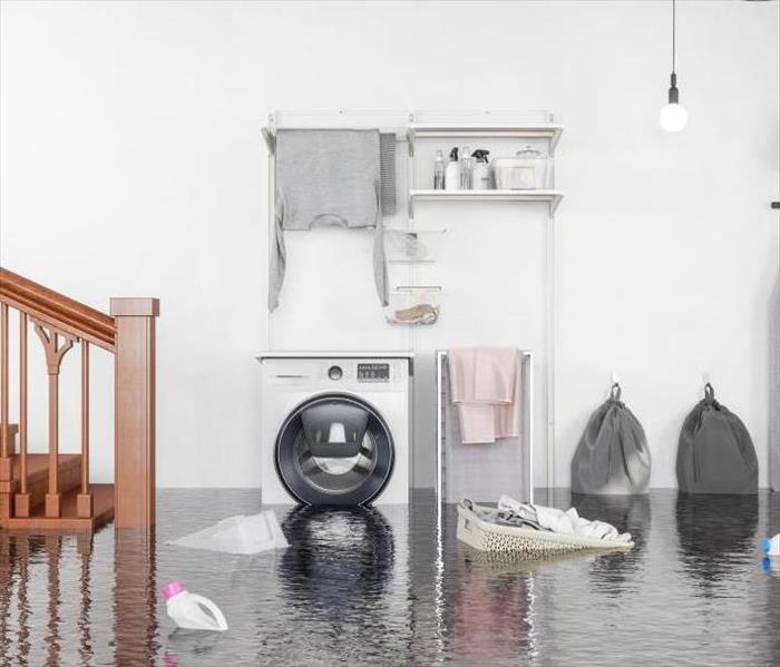 flooded laundry room with items floating on top