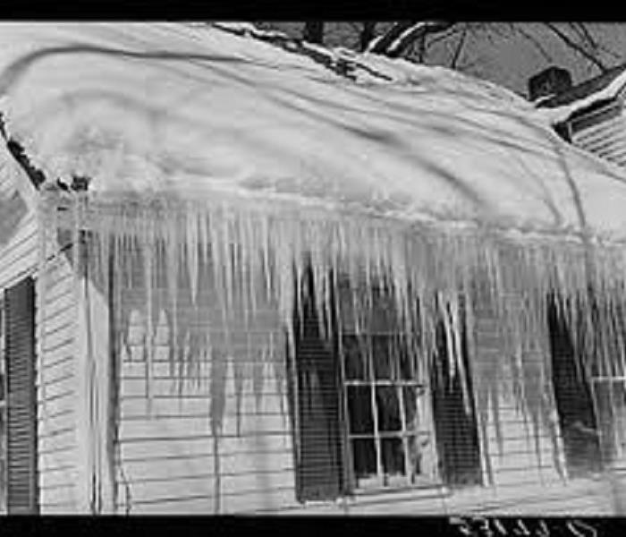 Snow and icicles on a white home