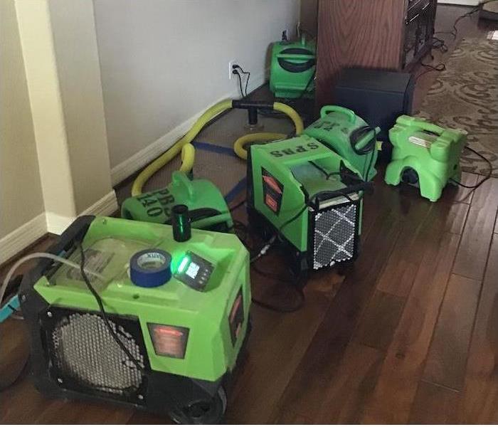 SERVPRO equipment on wood flooring in a living room. 